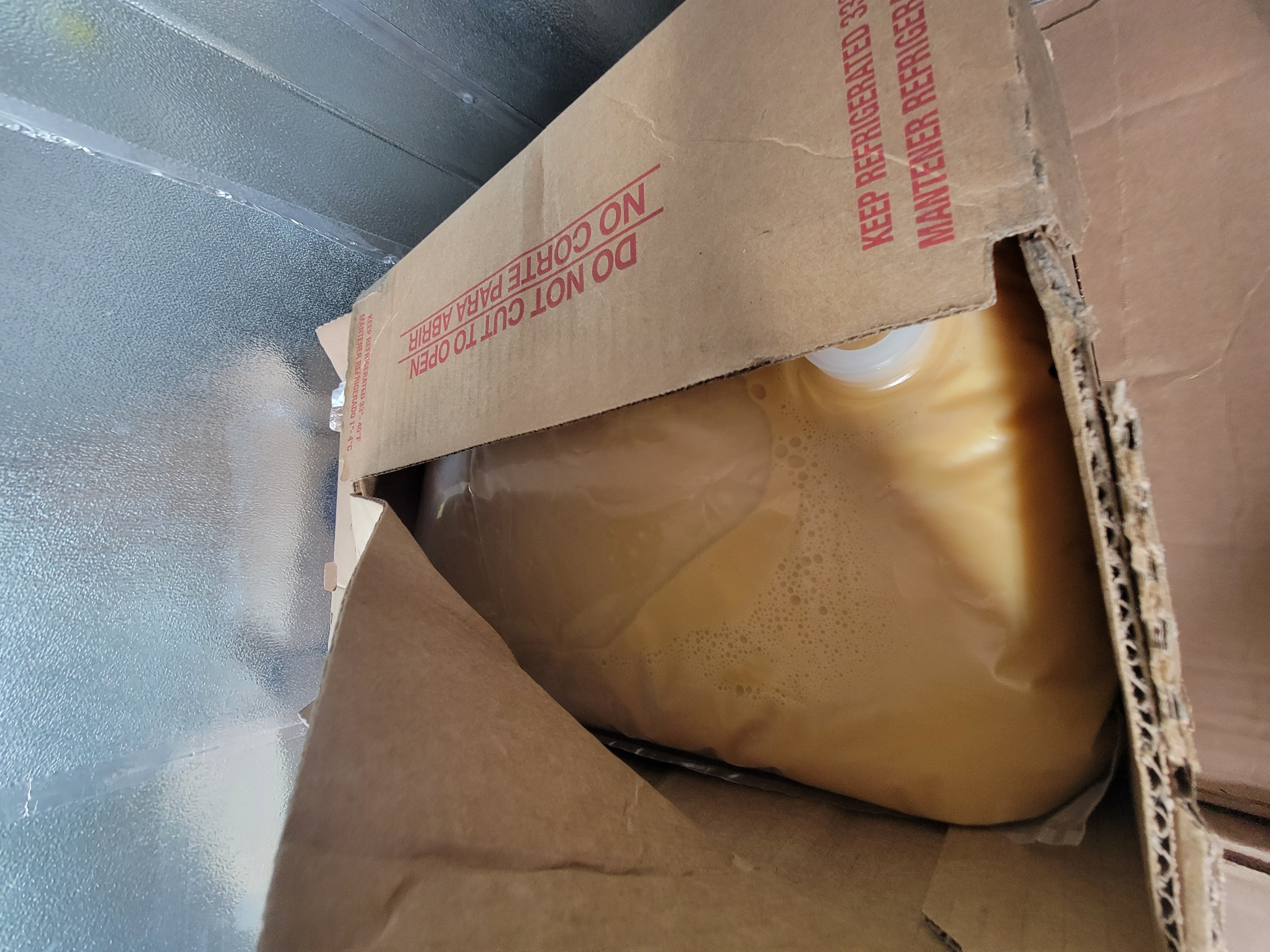 Cardboard box with bag of liquid whole egg sticking out.
